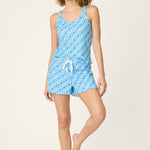 Woman wearing bay blue pajama set with colorful star print tank top and shorts