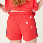 Red shorts with white star details and side stripes worn by model