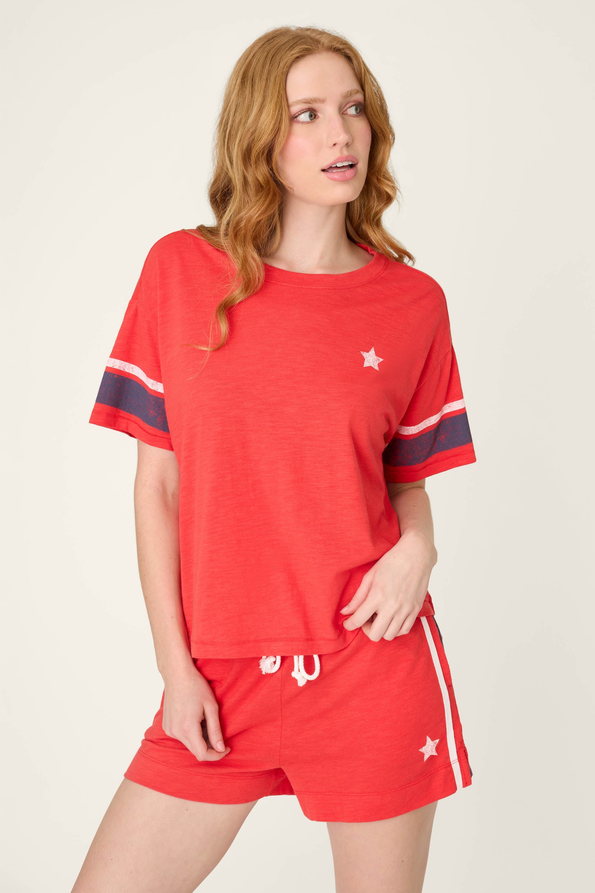 Woman wearing red short sleeve top with star detail and matching red shorts