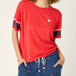 Woman wearing red short sleeve top with star detail and striped sleeves