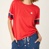 Woman wearing red short sleeve top with star detail and striped sleeves
