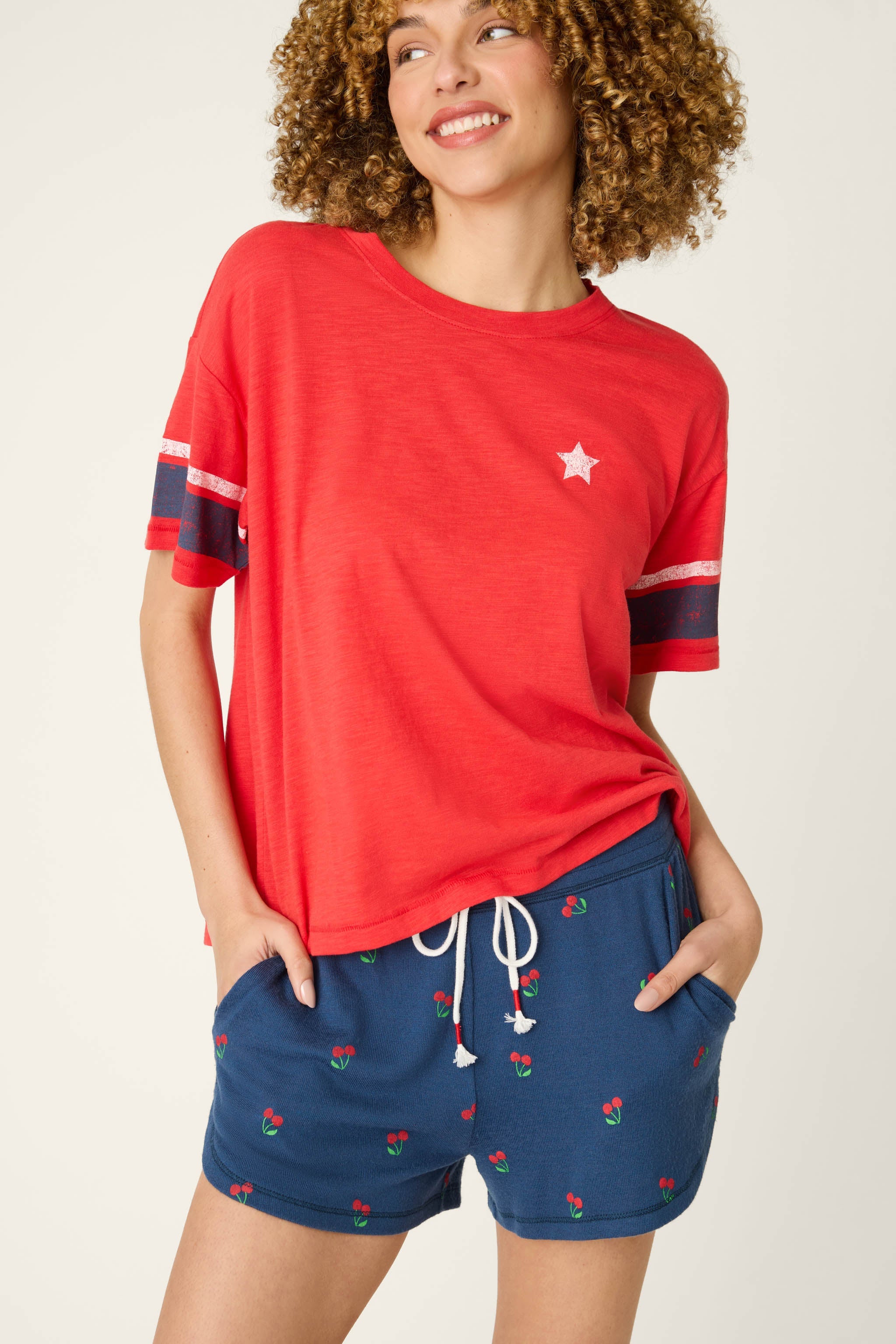 Woman wearing red short sleeve top with star detail and striped sleeves