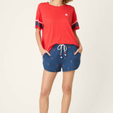 Woman wearing red short sleeve top with star logo and navy striped sleeves