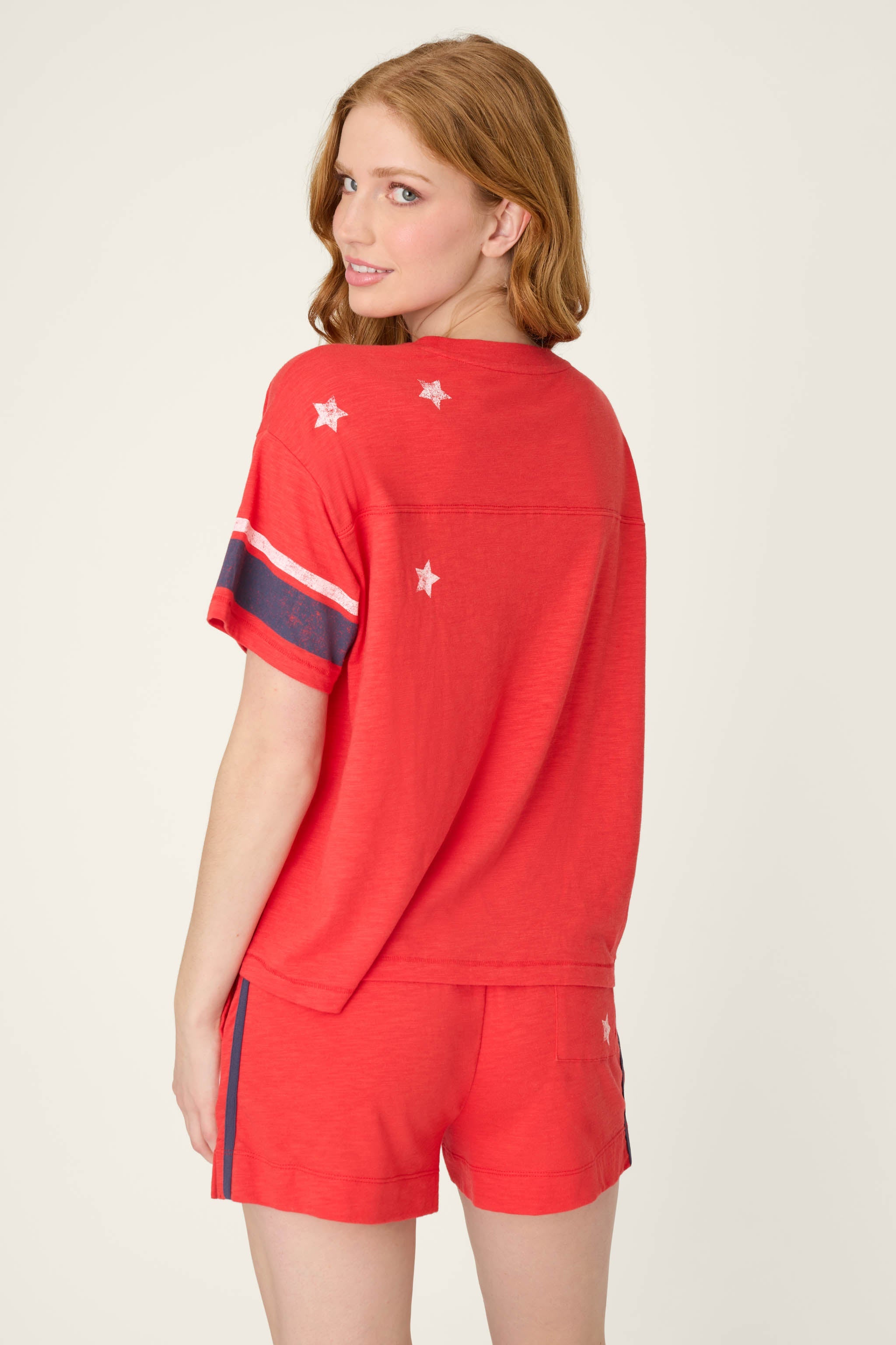 Woman wearing red short sleeve top with white stars and navy stripe details