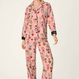 Woman wearing PJ Salvage Love Lockets pink flannel pajama set with matching hair tie