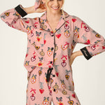 Woman wearing PJ Salvage Love Lockets pink flannel pajama set with heart and bow print