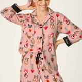 Woman wearing PJ Salvage Love Lockets pink flannel pajama set with heart and bow print