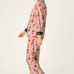Woman wearing PJ Salvage Love Lockets pink long sleeve flannel pajama set with hearts and bows print