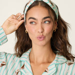 Model wearing PJ Salvage espresso martini print flannel pajama set with matching headband
