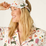 Smiling woman wearing PJ Salvage Saddle Up Western Print pajama set with matching sleep mask