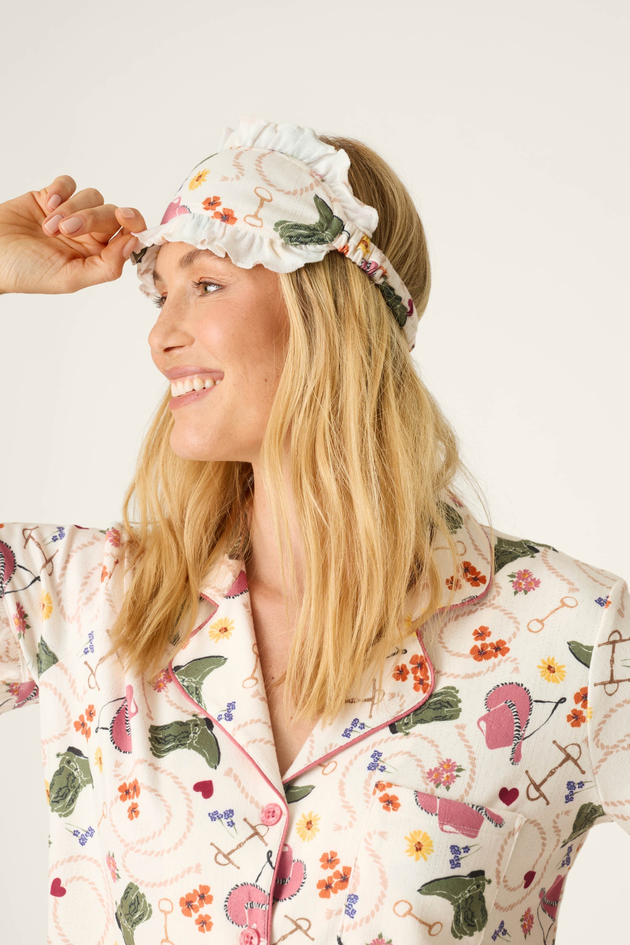 Smiling woman wearing PJ Salvage Saddle Up Western Print pajama set with matching sleep mask