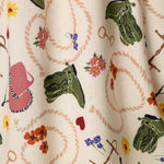 Close-up of PJ Salvage Saddle Up Western print fabric in nude with colorful western motifs