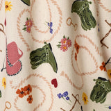 Close-up of PJ Salvage Saddle Up Western print fabric in nude with colorful western motifs