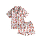 Children's pink satin pajama set with Santa face print, button-down shirt and shorts