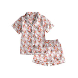 Children's pink satin pajama set with Santa face print, button-down shirt and shorts