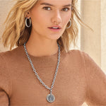 Woman wearing Brighton Interlok Tree of Life silver chain necklace with round medallion pendant