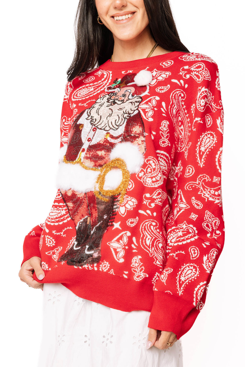 Woman wearing red paisley print cowboy Santa sweater with 3D pom detail