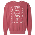 Mauve or dusty rose pigment-dyed crewneck sweatshirt featuring a whimsical white line graphic framing the text "Have yourself a merry little cocktail" above a drawing of a decorated martini glass.