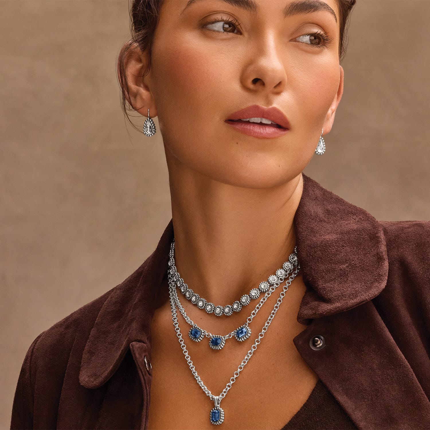 Model wearing Brighton Twinkle Luxe Trio Blue layered silver necklaces with blue stone pendants