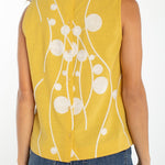 Yellow sleeveless top with cream embroidered circles and button back closure