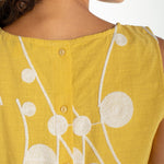 Yellow sleeveless top with cream embroidered circular botanical design and button back closure