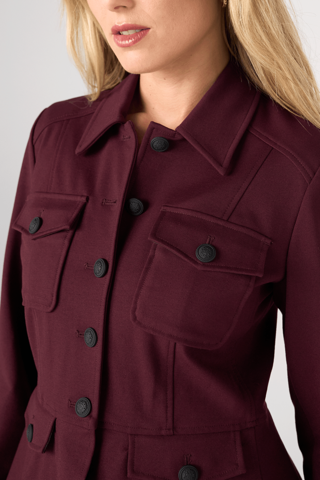 Liverpool Peplum Jacket in dark oxblood burgundy with black decorative buttons and chest pockets