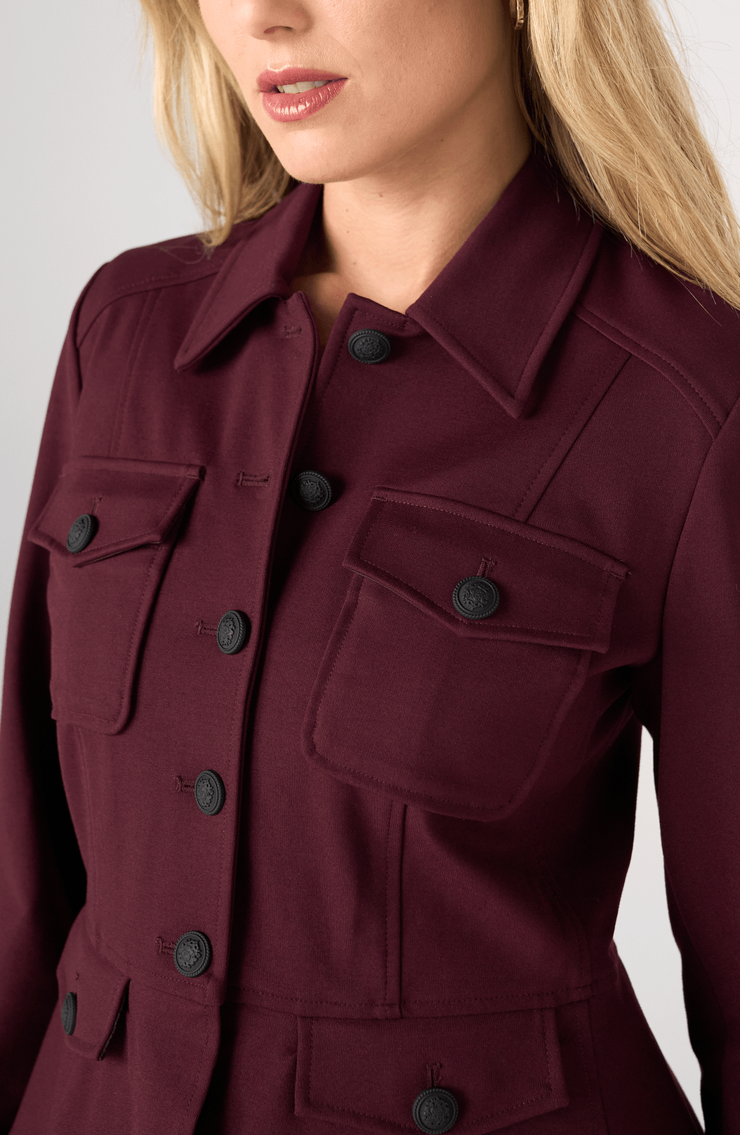 Liverpool Peplum Jacket in dark oxblood burgundy with black decorative buttons and chest pockets