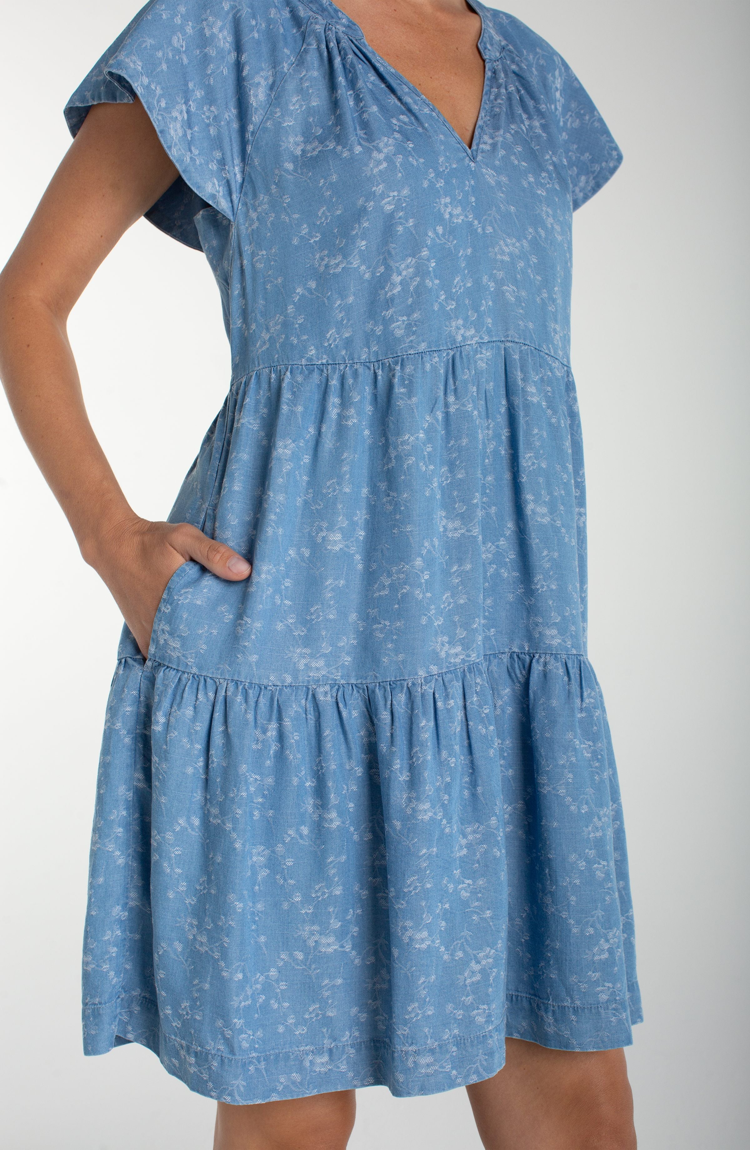 Liverpool Los Angeles, denim dress, floral mini dress, tiered dress with pockets, indigo roses, summer flutter sleeve dress, light wash denim dress, feminine casual style. at ooh la la! in 
Grapevine TX 76051