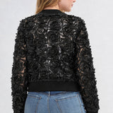 Black rosette bomber jacket with ribbed trim shown from back on female model with jeans