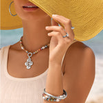 Brighton Vertigo Hues stretch bracelet with multicolor beads, pearls, and silver bangle on model at beach